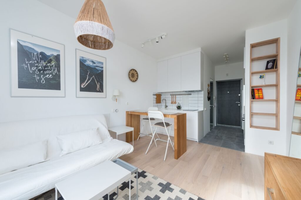 Small apartment living room with a white sofa and compact open kitchen